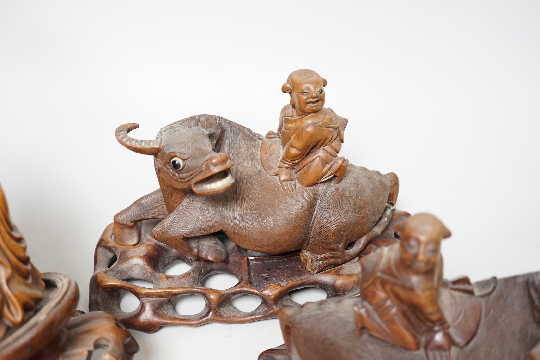 A pair of Chinese carved hardwood buffalo carvings, and a similar figure of a luohan, latter 24cm - damaged